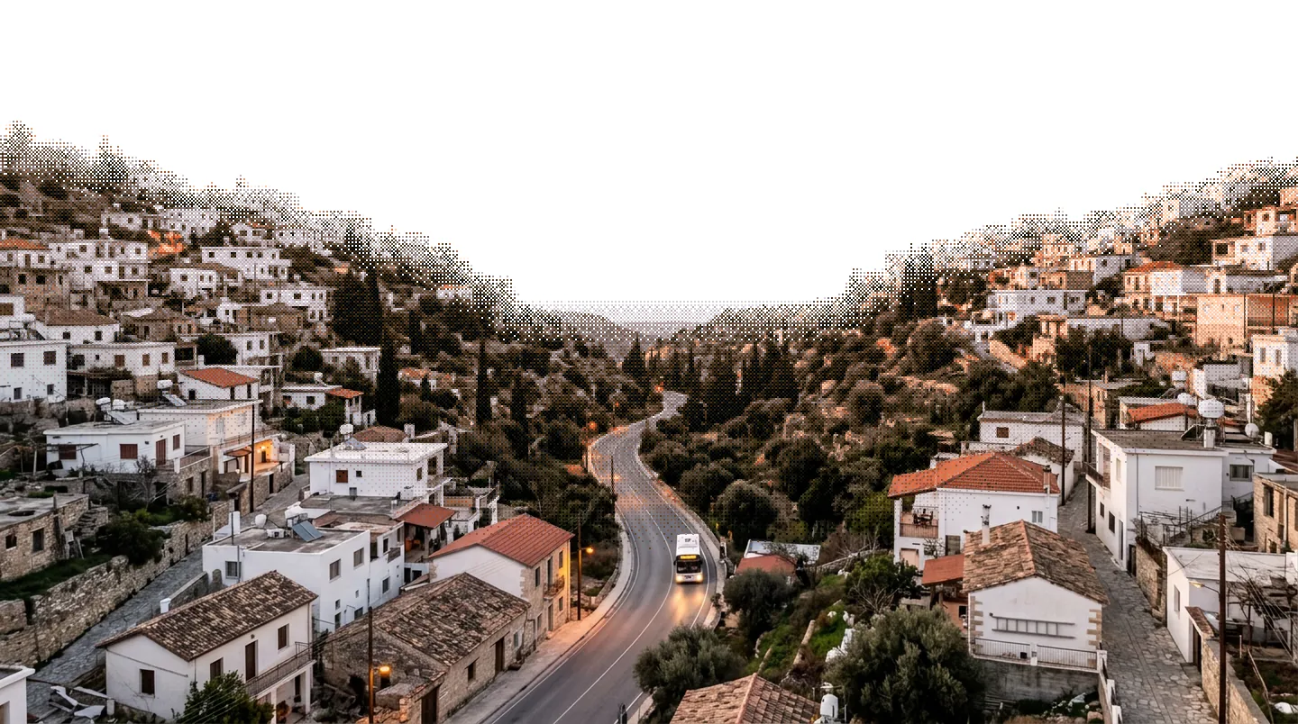 A Cypriot hill town at dawn, a bus on the road through the valley